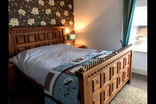un letto in legno in una camera da letto con finestra di McCormacs Farmhouse a Mullanalaghta