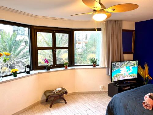 Un dormitorio con una cama y una ventana con un televisor. en SuperbeStudio in Nice - 450m of the sea- garden view, en Niza