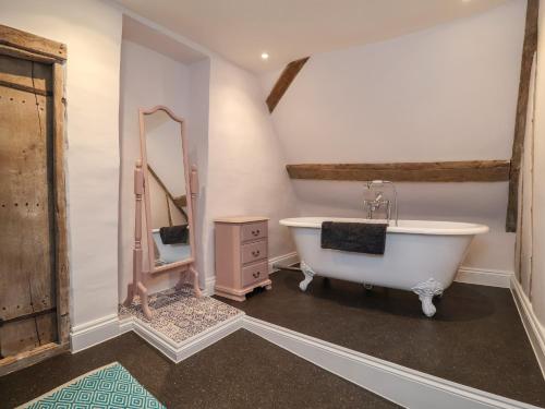 a bathroom with a tub and a sink and a mirror at South Grange House in Sibton