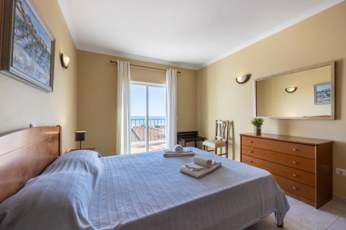 a bedroom with a large bed and a large window at Apartamento Meia Praia in Lagos