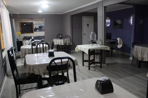un comedor con mesas y sillas y una habitación con paredes púrpuras en HOTEL LOYOLA, en Coyhaique