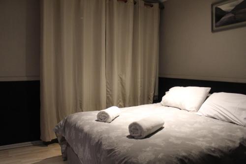 1 dormitorio con 1 cama con toallas en HOTEL LOYOLA, en Coyhaique