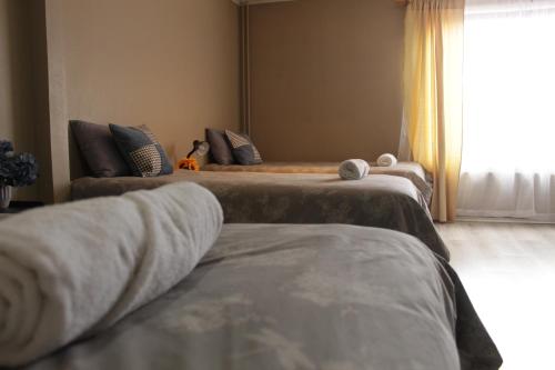 three beds in a room with a window at HOTEL LOYOLA in Coihaique