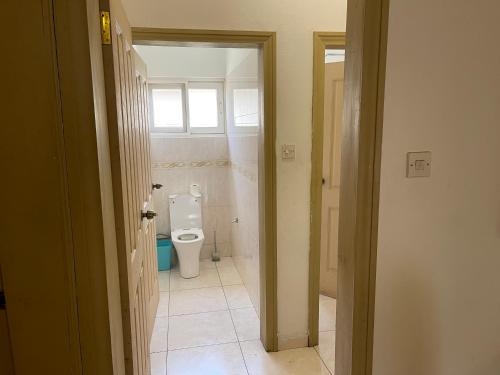 a bathroom with a toilet and a window at AGASTEV Guesthouse GH in Accra