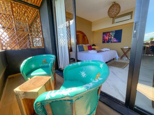 Habitación con 2 sillas verdes y 1 cama en Akuazul Resorts Adults Only en Cancún