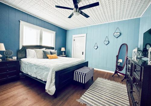 a blue bedroom with a bed and a ceiling fan at Windmill Inn in Abilene