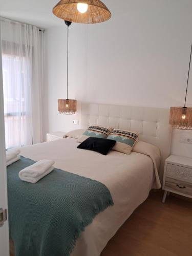 a white bedroom with a large bed with two pillows at Apartamentos Rúa Centro Calatayud in Calatayud