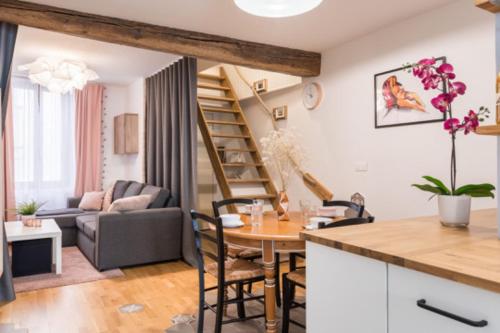 een keuken en een woonkamer met een tafel en een wenteltrap bij Charmant duplex deux chambres Saxe Gambetta in Lyon