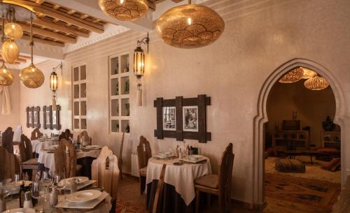 a dining room with tables with white tablecloths at Eden Boutique Hotel in Tamellalt