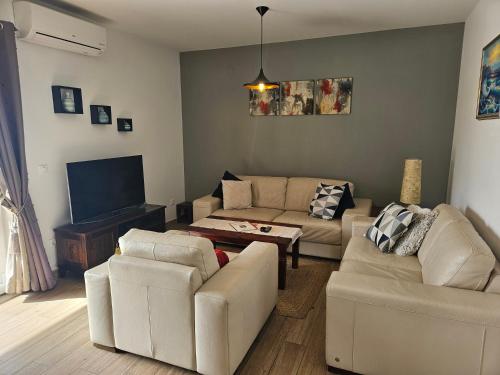 ein Wohnzimmer mit weißen Möbeln und einem Flachbild-TV in der Unterkunft Apartment Marbella in Dubrovnik