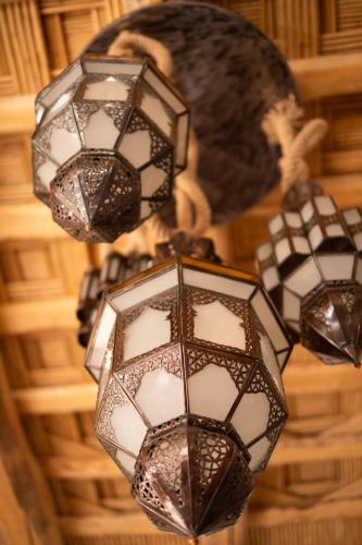 a group of lights hanging from a ceiling at Eden Boutique Hotel in Tamellalt
