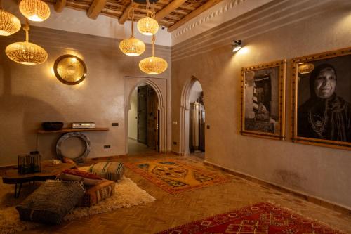 a living room with a couch and a portrait on the wall at Eden Boutique Hotel in Tamellalt