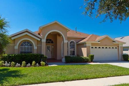 a large house with a driveway at 35 - Relax & Play 4-Bed Villa with Pool & Game Room Minutes to Disney in Orlando