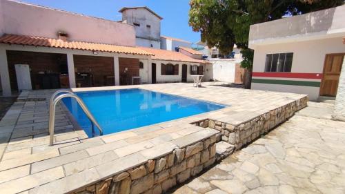 uma piscina em frente a uma casa em CASA 7 qts sendo 4 suites, Piscina Churrasqueira 200 m praia Anjos em Arraial do Cabo