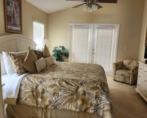 a bedroom with a large bed and a chair at 35 - Fabulous 4 Bedroom Villa with South Facing Pool in Orlando