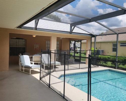 an open patio with a swimming pool and a house at 35 - Relax & Play 4-Bed Villa with Pool & Game Room Minutes to Disney in Orlando