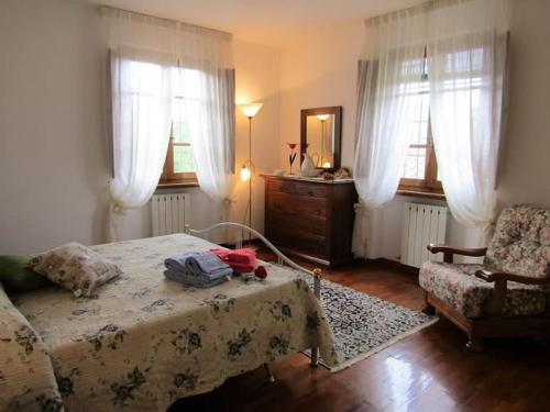 sypialnia z łóżkiem, krzesłem i lustrem w obiekcie Casa vacanze Lulù w mieście Camaiore