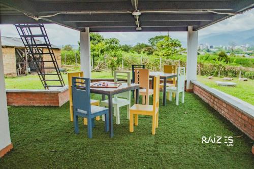 a group of tables and chairs on a patio at Raizes AXM I Casa Campestre I Armenia, Quindío, Colombia in Armenia