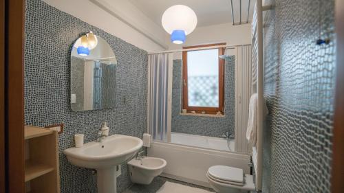 ポリニャーノ・ア・マーレにあるIl Vicolettoのバスルーム(洗面台、トイレ、鏡付)