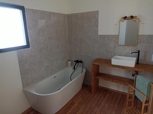 La salle de bains est pourvue d'une baignoire et d'un lavabo. dans l'établissement Grande maison de vacances, à Perpignan