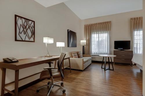 Habitación de hotel con escritorio y sala de estar. en Staybridge Suites Tallahassee I-10 East, an IHG Hotel en Tallahassee