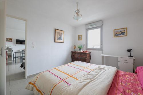 ein weißes Schlafzimmer mit einem Bett und einer Küche in der Unterkunft T2 Calme & Charmant proche de Toulouse - A 2min du Campus TBS in Quint-Fonsegrives