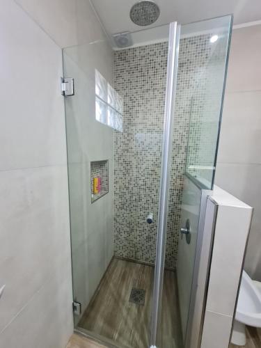 y baño con ducha y puerta de cristal. en LA GARDIA en Cañuelas