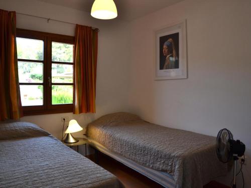 ein Schlafzimmer mit zwei Betten und einem Fenster in der Unterkunft Casa con Piscina Privada y Jardín Cerca de la Playa en L'Estartit - ES-323-6 in L'Estartit