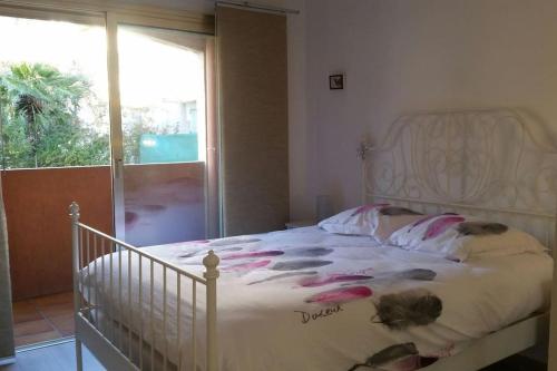 une chambre avec un lit blanc avec des fleurs dessus dans l'établissement Beautifull 2 rooms appt, closed all main sights!, à Saint-Raphaël