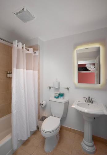 a white bathroom with a toilet and a sink at Paradise Inn - Adult Exclusive in Key West