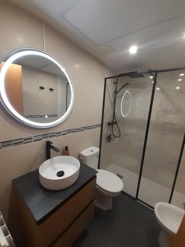 a bathroom with a sink and a toilet and a mirror at Apartamentos Rúa Centro Calatayud in Calatayud