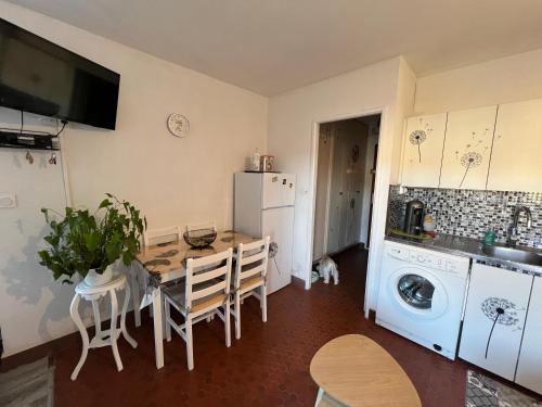 Il comprend une cuisine équipée d'une table et d'un réfrigérateur. dans l'établissement Kanumera Barcarès, vue mer, balcon et parking privé, au Barcarès