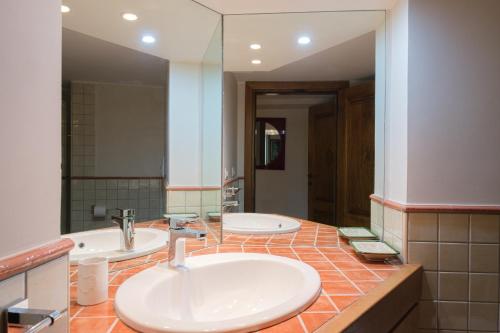 een badkamer met 2 wastafels en een grote spiegel bij [Portisco-Costa Smeralda] Villa Giardino e Vista Mare in Marina di Portisco