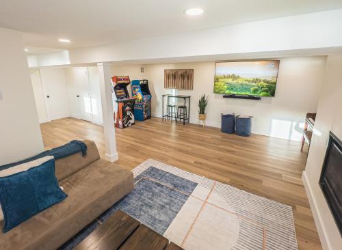a living room with a couch and a flat screen tv at Lakeside, Dock, Hot Tub, Kayaks, Arcade, Playset in Lake Ariel