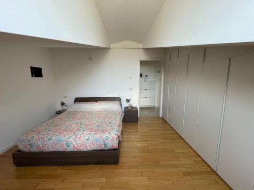 a bedroom with a bed in a room with white walls at Elia Loft in Riva del Garda
