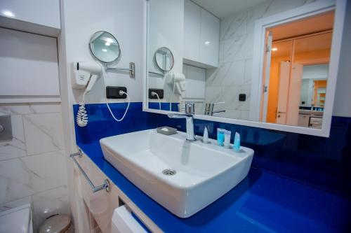 Welcome To Batumi في باتومي: حمام مع حوض أبيض ومرآة