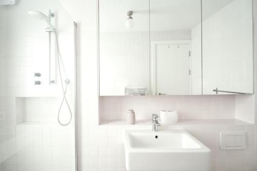 a white bathroom with a sink and a shower at Luxury London Townhouse - Hidden Gem in London