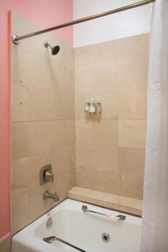 a bathroom with a shower with a tub and a sink at Paradise Inn - Adult Exclusive in Key West