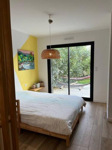 une chambre avec un lit et une grande fenêtre dans l'établissement Villa au Coeur de la presqu'ile, à Crozon