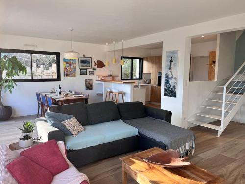un salon avec un canapé et une table et une cuisine dans l'établissement Villa au Coeur de la presqu'ile, à Crozon