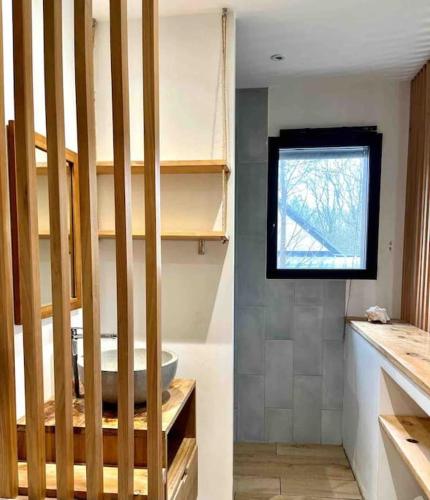 une salle de bain avec un lavabo et une fenêtre dans l'établissement Villa au Coeur de la presqu'ile, à Crozon