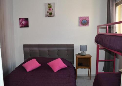 - une chambre avec un lit et 2 oreillers roses dans l'établissement Résidence LES NEFS DES SABLES - 2 Pièces pour 5 Personnes 24, à Port-Leucate