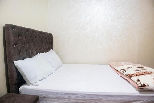 a bed with white sheets and a brown headboard at ADAM 2 in Dakhla