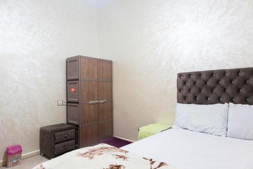 a bedroom with a bed and a wooden cabinet at ADAM 2 in Dakhla