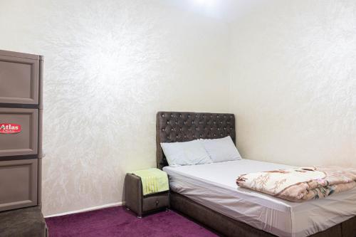 Habitación pequeña con cama y taburete en ADAM 2, en Dakhla