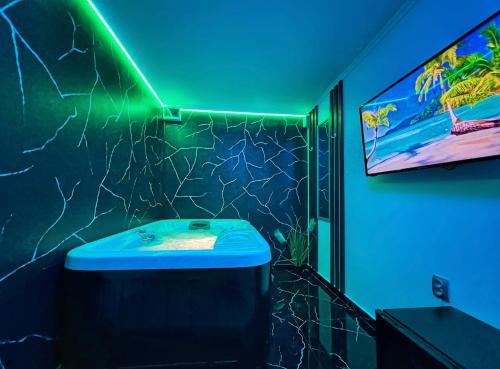a bathroom with a sink and a tv on the wall at Luxor - Jacuzzi&Cozy Apartments in Sibiu