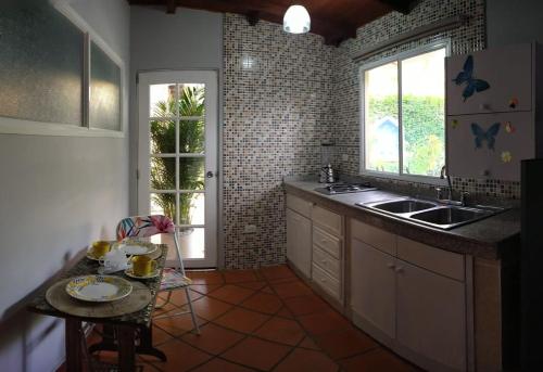 a kitchen with a sink and a table and a window at Portoazul Casa de Playa in Puerto Colombia