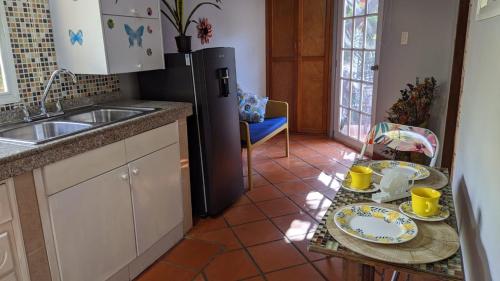 a kitchen with a refrigerator and a table with dishes on it at Portoazul Casa de Playa in Puerto Colombia