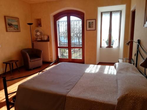 - une chambre avec un lit, une chaise et une fenêtre dans l'établissement Casale Massina APPARTAMENTO PERLA, à Salò
