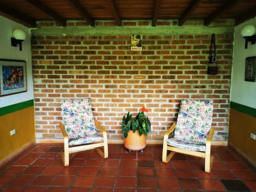 two chairs sitting next to a brick wall at Alojamiento el Recuerdo in Montenegro